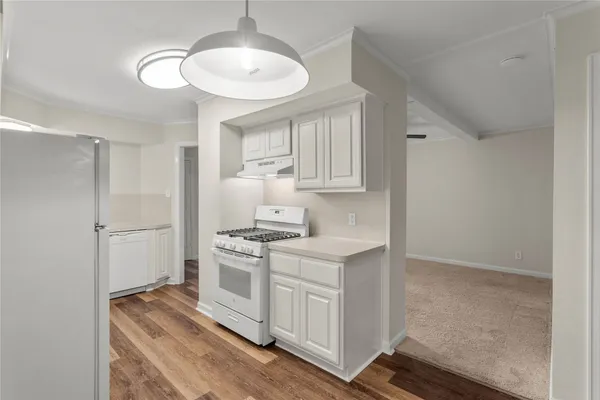 a kitchen with a stove window and cabinets