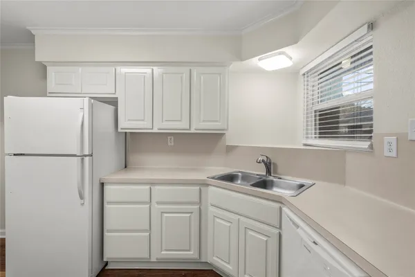 a kitchen with white cabinets and white appliances