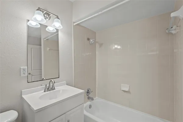 a bathroom with a sink a toilet a mirror and shower