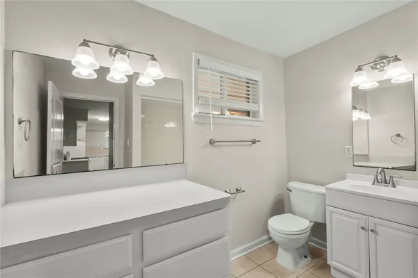 a bathroom with a sink a toilet and a mirror