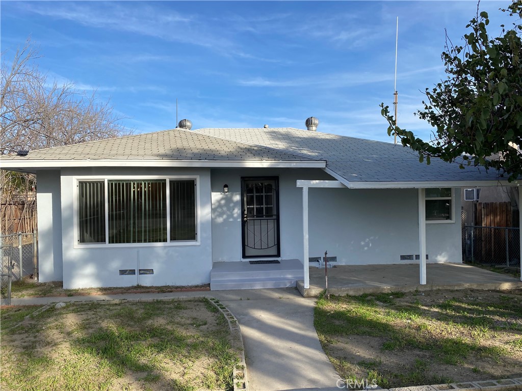 177 South Maple Avenue Rialto, CA 92335 - Photo 1 of 1 a view of a white house with large windows and a small yard with wooden fence