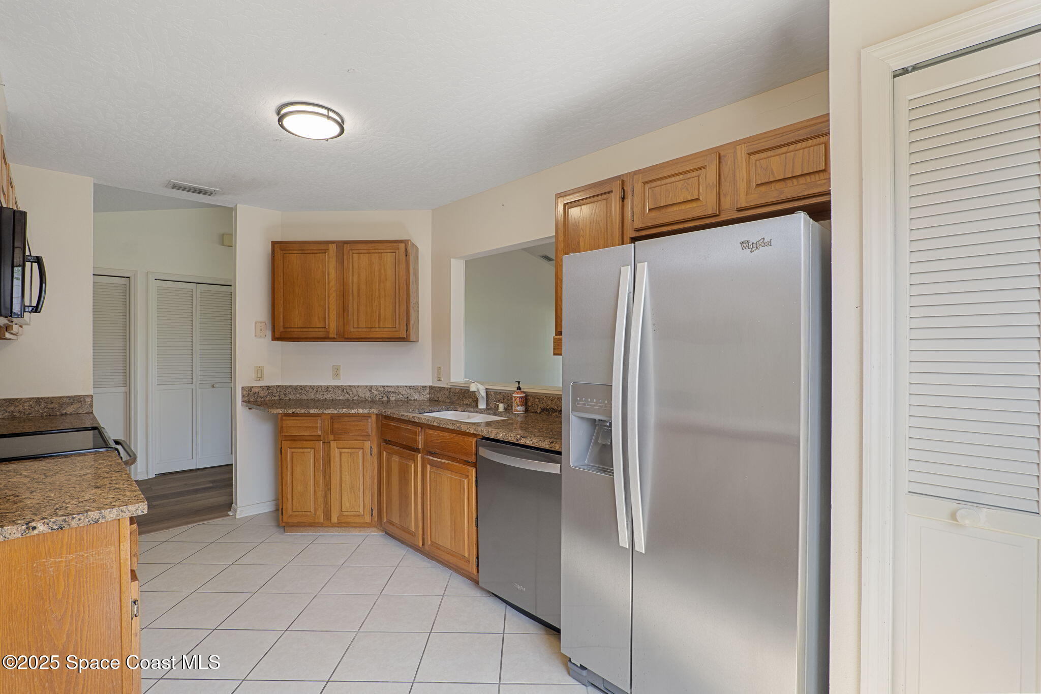 810 Ridge Lake Drive Melbourne, FL 32940 - Photo 8 of 25 a kitchen with stainless steel appliances granite countertop a refrigerator and a sink