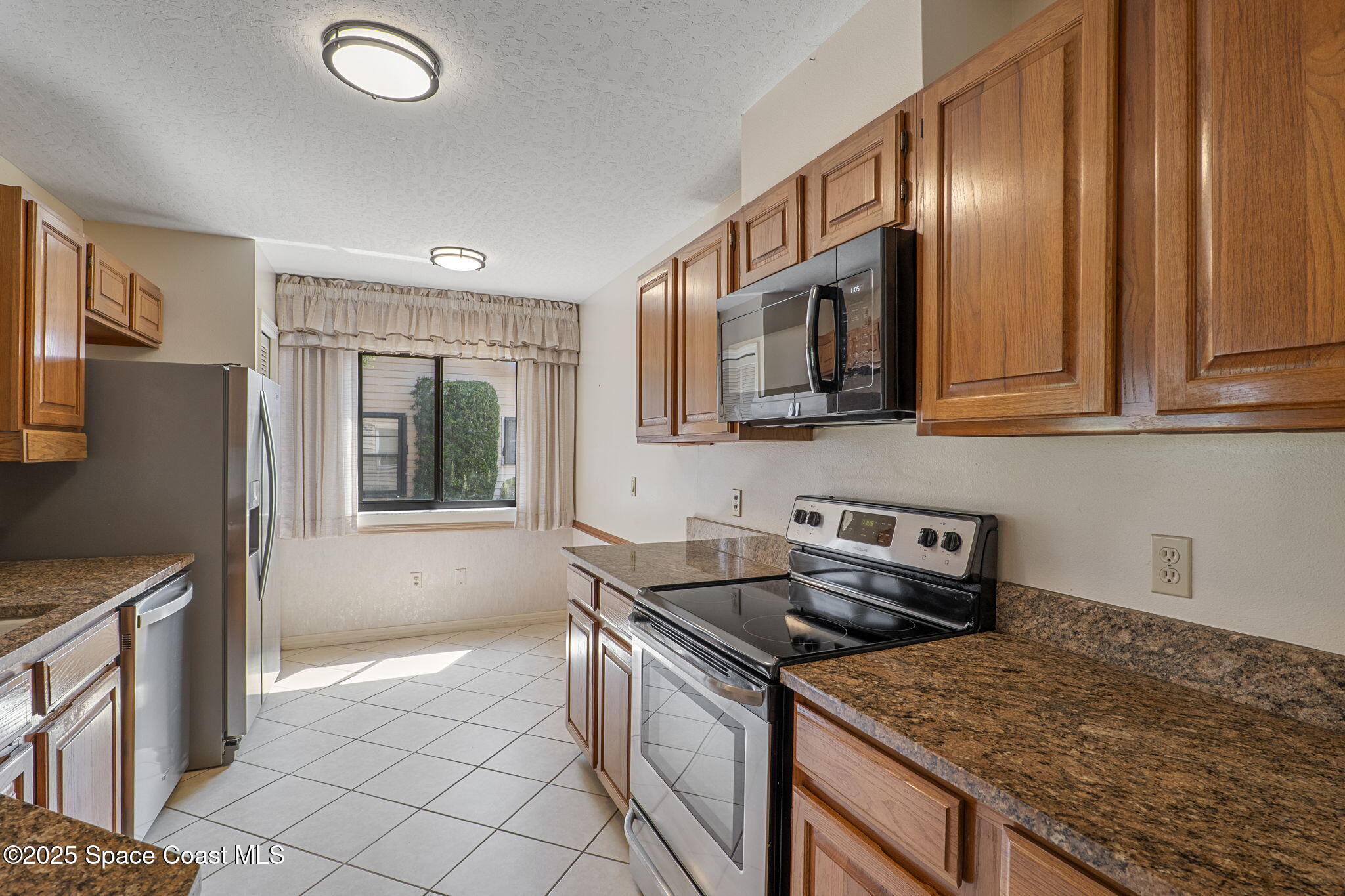 810 Ridge Lake Drive Melbourne, FL 32940 - Photo 9 of 25 a kitchen that has a sink a stove and a microwave