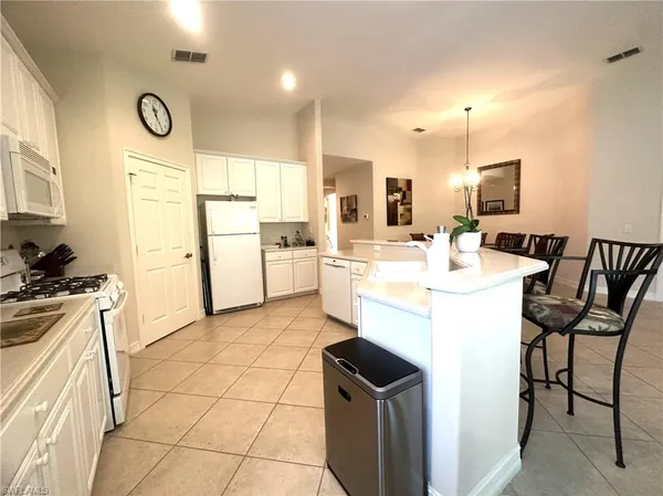 a kitchen with cabinets and chairs
