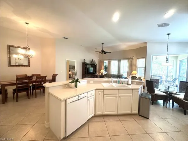 a kitchen with a sink window and chairs