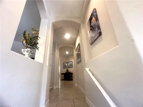 a view of a hallway with entryway and furniture