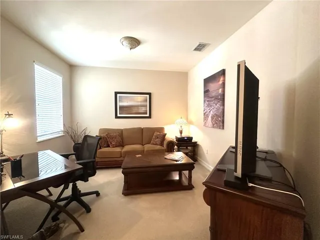 a living room with furniture flat screen tv and a window