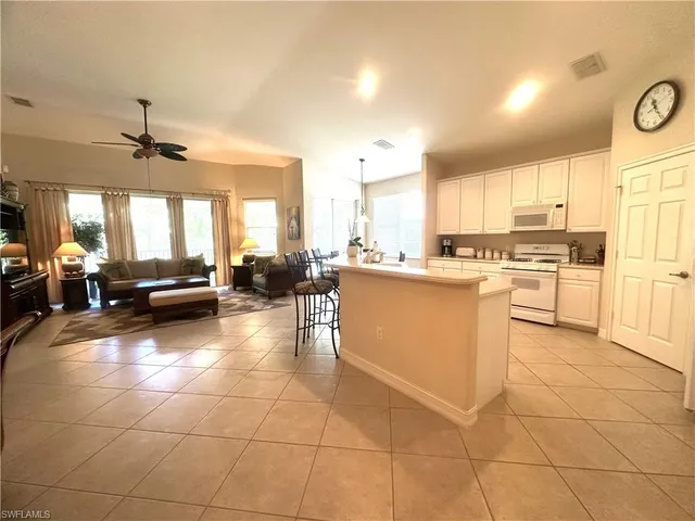 a large white kitchen with a large window and kitchen view