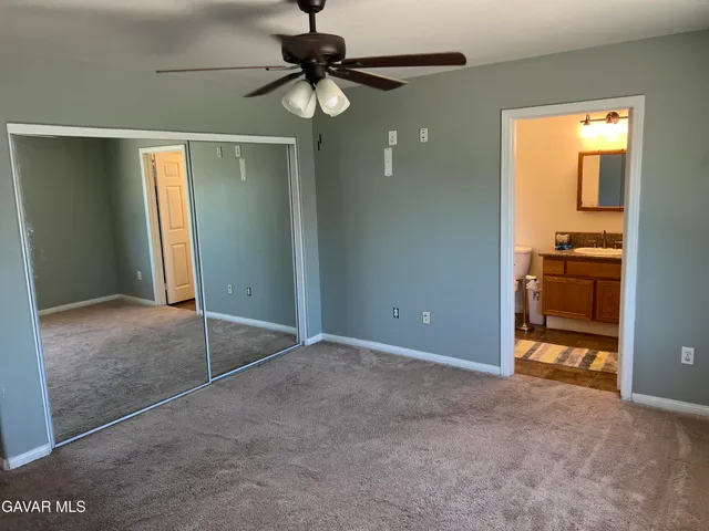a view of a livingroom with a chandelier fan and a kitchen