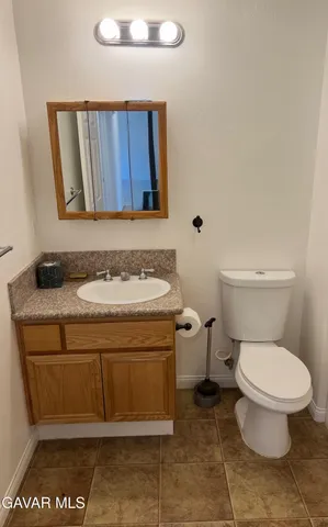 a bathroom with a granite countertop toilet and a sink