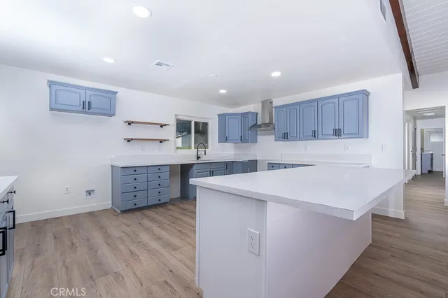 a kitchen with stainless steel appliances sink cabinets and wooden floor