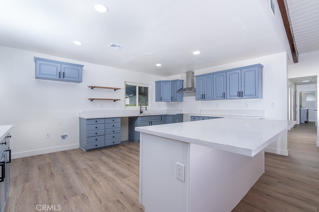 6026 Moraga Avenue Riverside, CA 92509 - Photo 13 of 42 a kitchen with stainless steel appliances sink cabinets and wooden floor