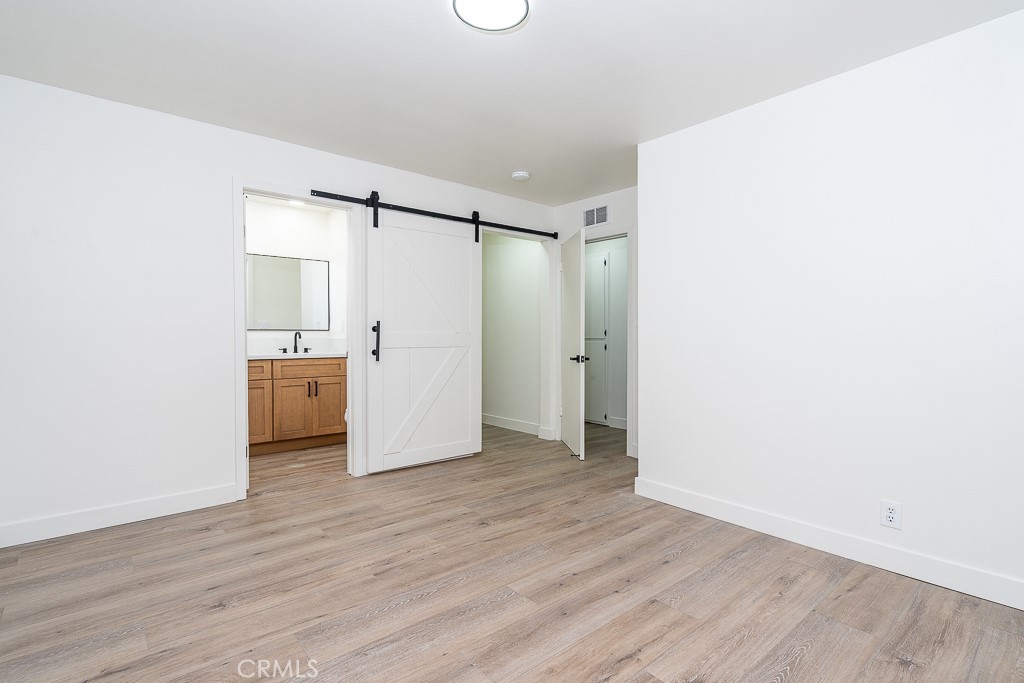 6026 Moraga Avenue Riverside, CA 92509 - Photo 25 of 42 a view of a kitchen with a white cabinet and wooden floor