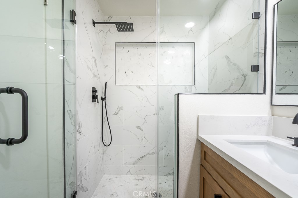 6026 Moraga Avenue Riverside, CA 92509 - Photo 29 of 42 a bathroom with a shower sink and mirror