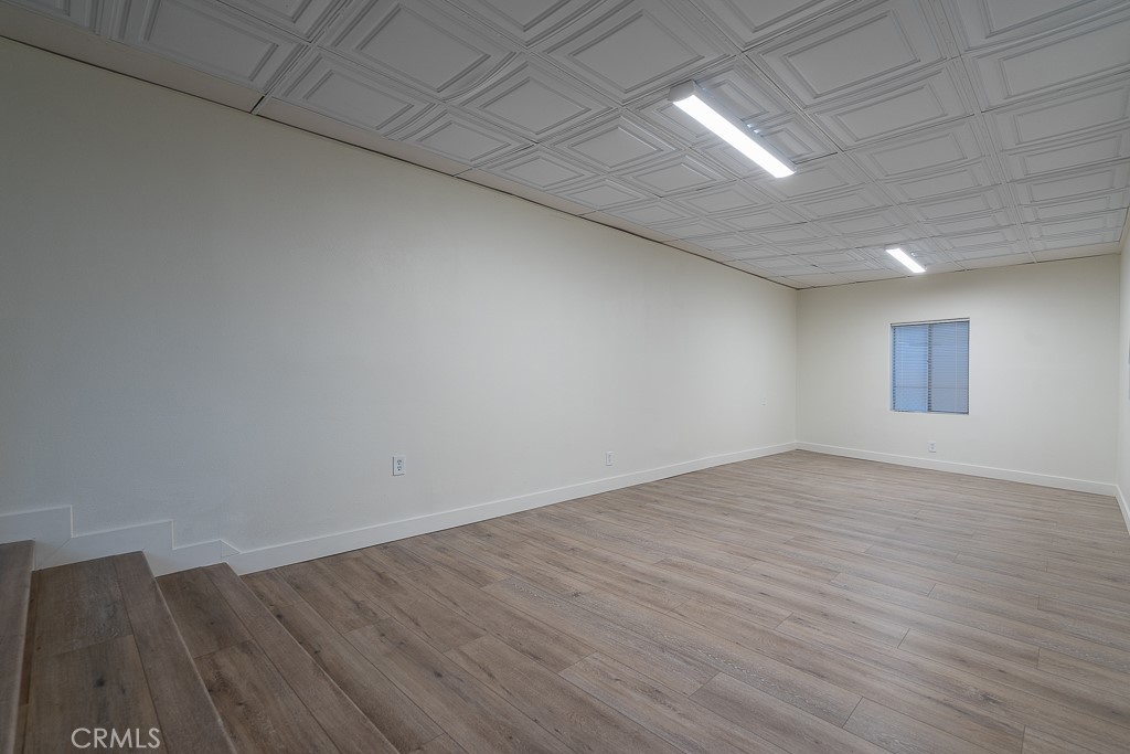 6026 Moraga Avenue Riverside, CA 92509 - Photo 9 of 42 an empty room with wooden floor and windows