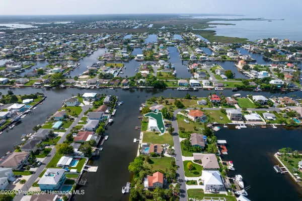 an aerial view of lake and residential houses with outdoor space