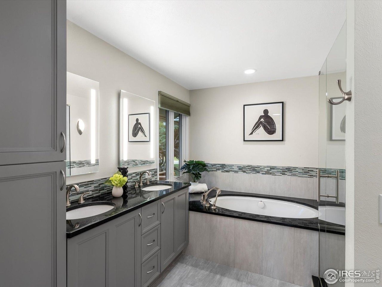 6972 Roaring Fork Trail Boulder, CO 80301 - Photo 16 of 35 a bathroom with a granite countertop tub a sink and mirror