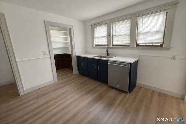 a kitchen with stainless steel appliances granite countertop a sink a stove a refrigerator and wooden floor