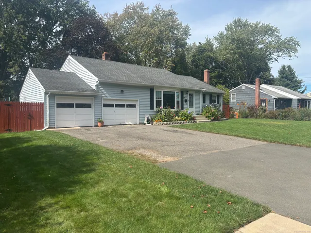 a front view of a house with a yard and trees