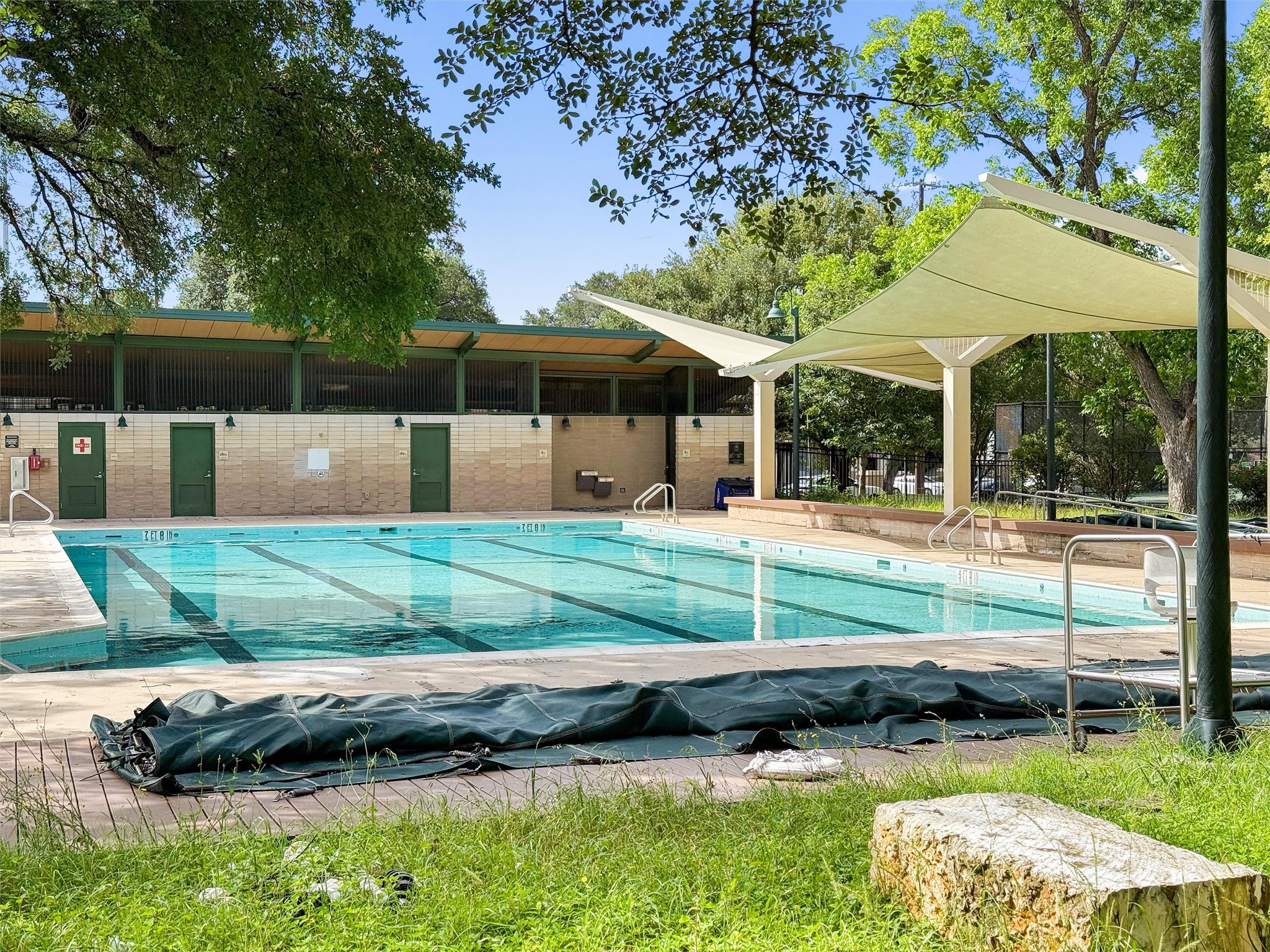 2208 Enfield Road, Unit 10500 Austin, TX 78703 - Photo 27 of 34 Expansive outdoor swimming pool featuring lane lines, a surrounding concrete deck, and multiple entry railings