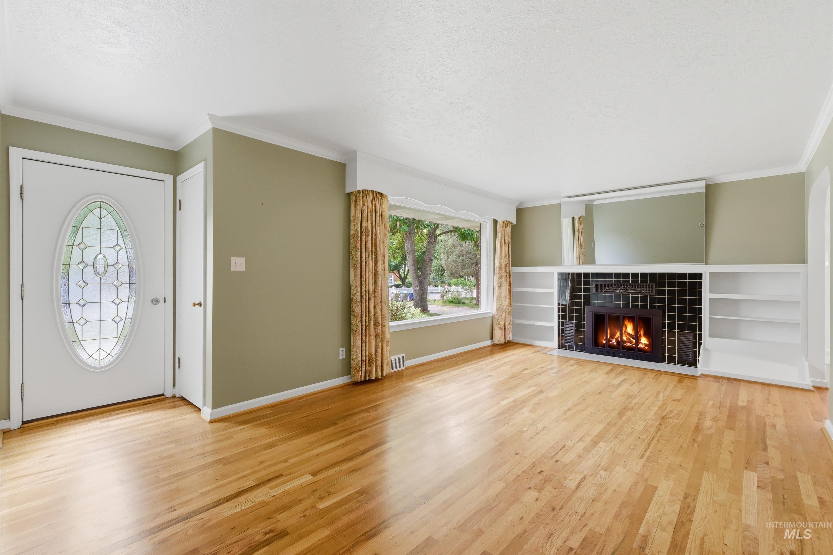 504 West Howe Street Boise, ID 83706 - Photo 7 of 47 Spacious living area featuring light wood flooring, a fireplace with black tile surround, and built-in shelving