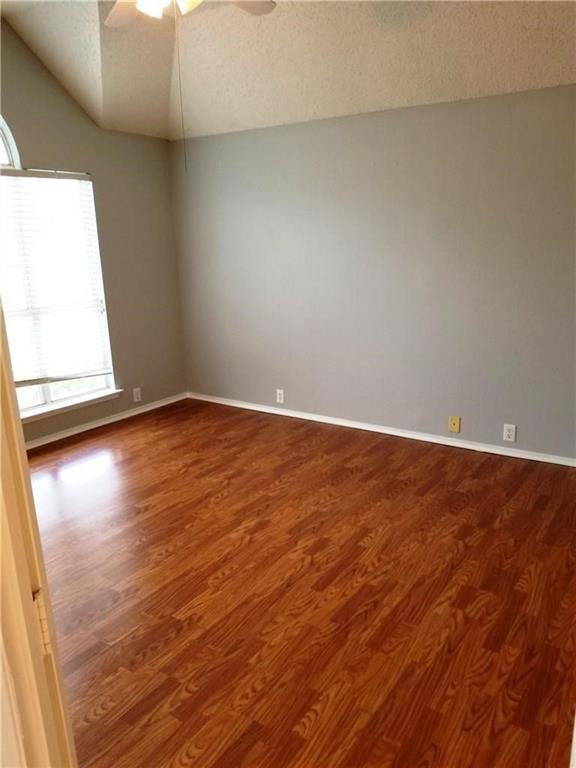 1100 Raleigh Drive Lewisville, TX 75077 - Photo 16 of 19 en empty room with wooden floor and windows