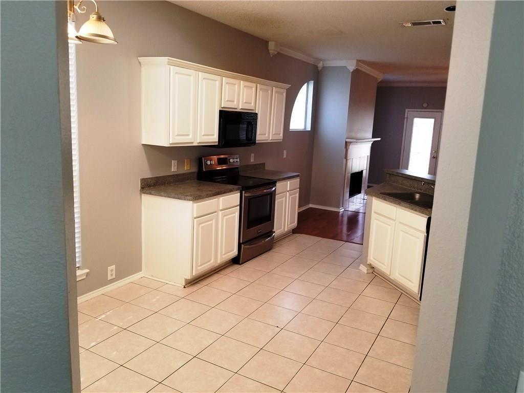 1100 Raleigh Drive Lewisville, TX 75077 - Photo 6 of 19 a kitchen with granite countertop a sink a stove top oven and cabinetry