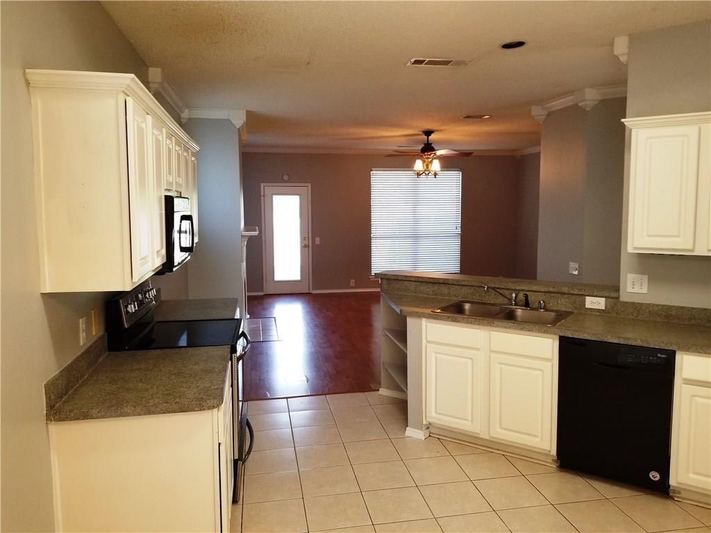 1100 Raleigh Drive Lewisville, TX 75077 - Photo 7 of 19 a kitchen with a sink a stove top oven and cabinets