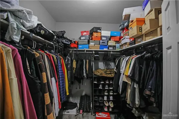 a view of walk in closet with clothes