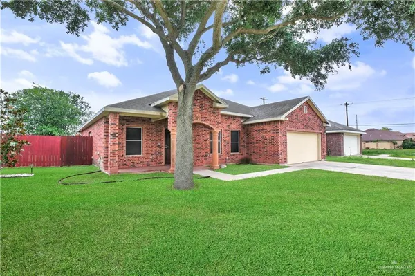 a front view of a house with a yard and trees