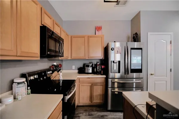 a kitchen with stainless steel appliances a stove refrigerator sink and cabinets