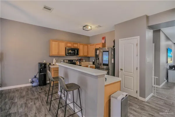 a kitchen with a refrigerator and a stove top oven