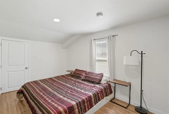 a bedroom with a bed and wooden floor