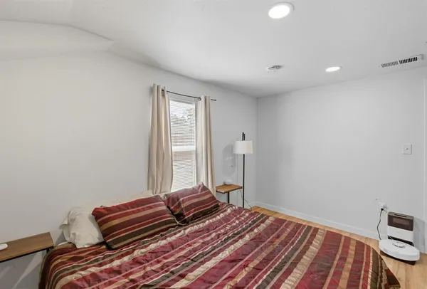 a bedroom with a bed and wooden floor
