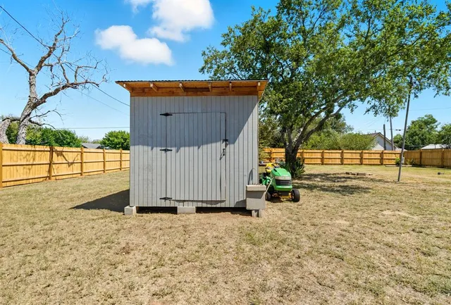 a view of backyard with wooden fence