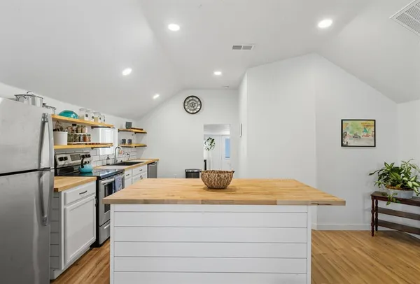 a kitchen with kitchen island sink stove and refrigerator