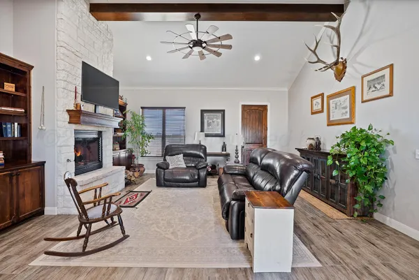 a kitchen with stainless steel appliances granite countertop a refrigerator a sink dishwasher a stove and a dining table with wooden floor