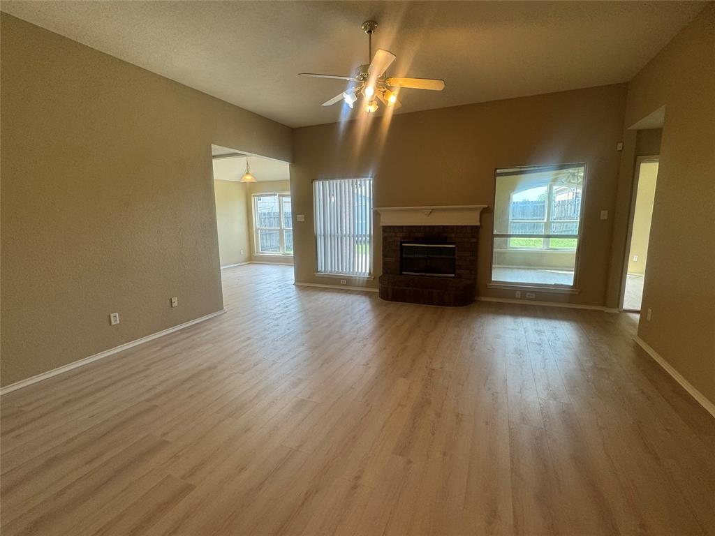 908 Cedar Ridge Lane Burleson, TX 76028 - Photo 4 of 24 an empty room with wooden floor fireplace and windows