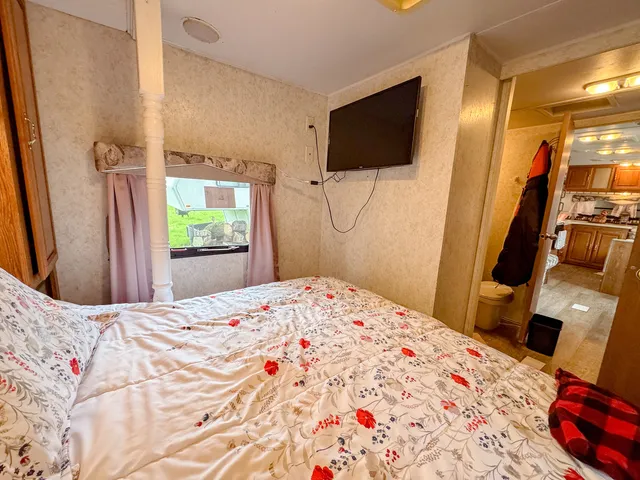 a bedroom with a bed and a flat screen tv