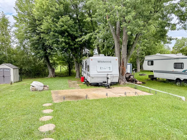 a view of backyard with a barn and large trees