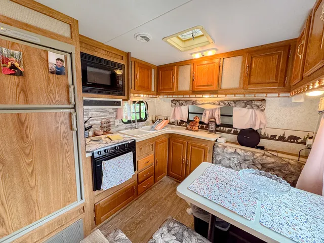 a kitchen with stainless steel appliances granite countertop a stove a sink dishwasher and a refrigerator with wooden floor