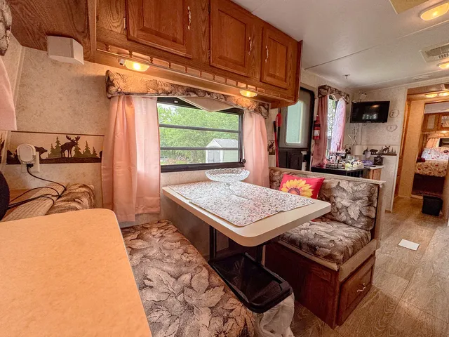 a living room with a table chairs and a refrigerator