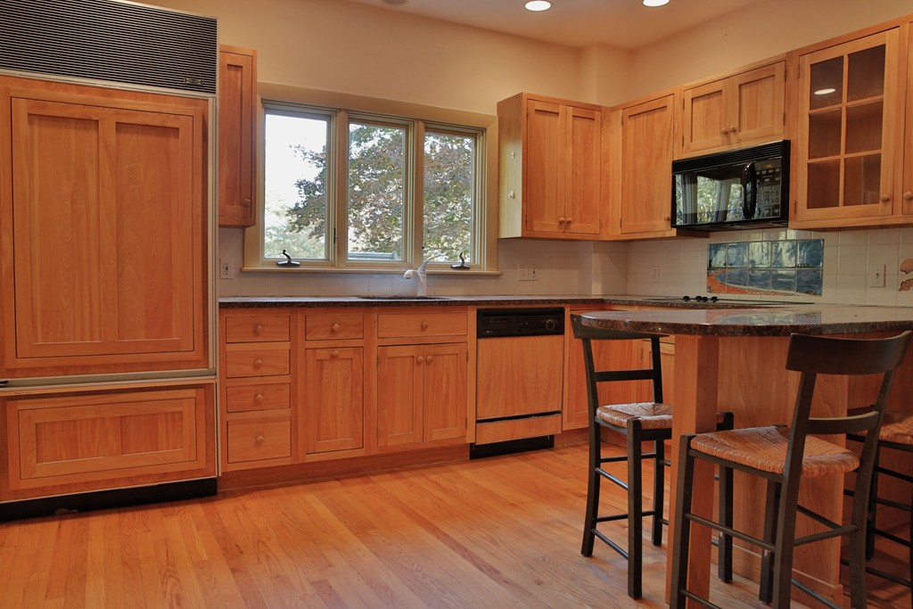 15 Leather Lane Beverly, MA 01915 - Photo 12 of 24 a kitchen with stainless steel appliances granite countertop a stove top oven a sink and dishwasher with wooden floor