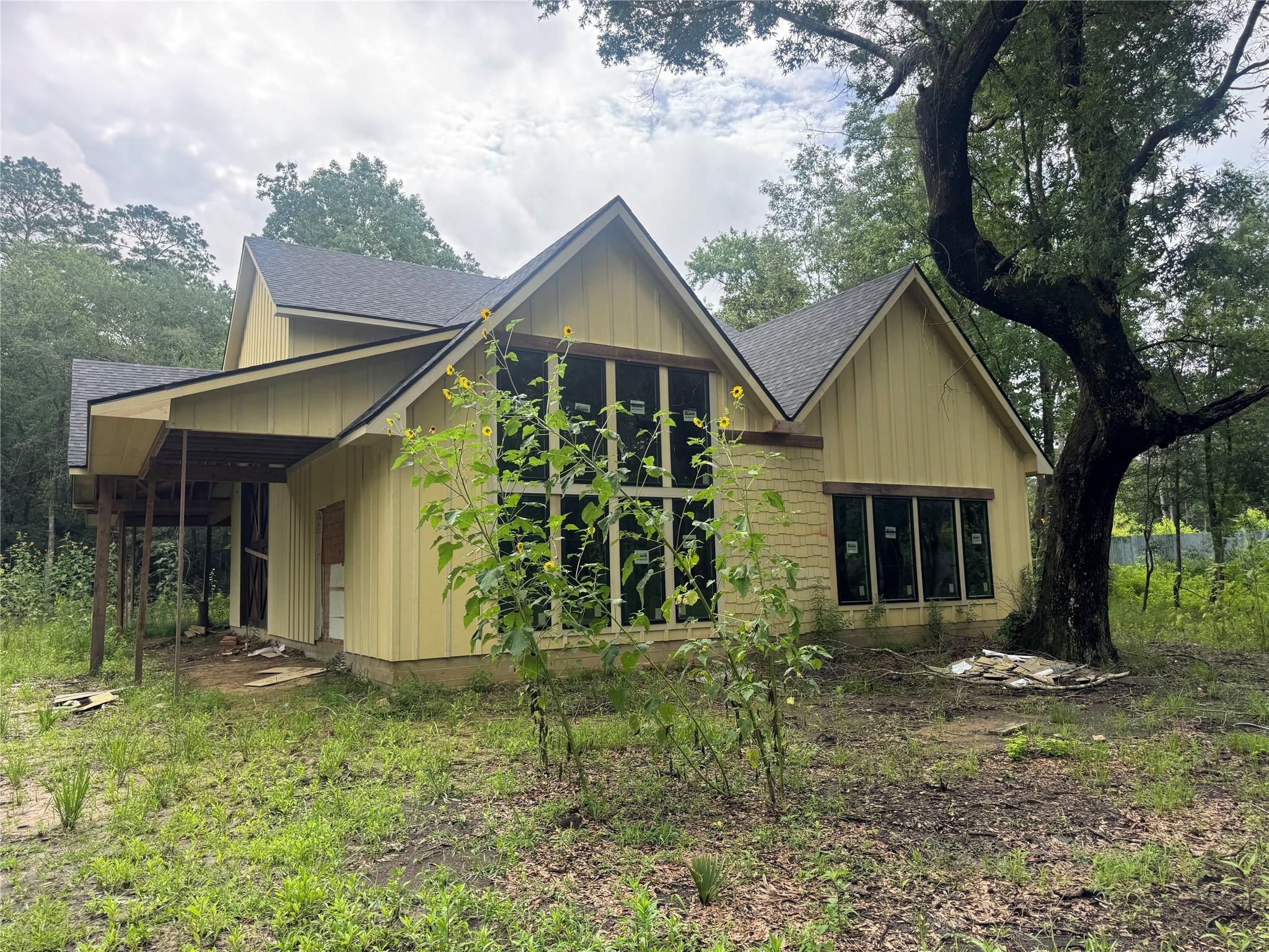 9813 Fm 563 Road Liberty, TX 77575 - Photo 3 of 8 New windows and a new roof, offering a solid foundation for completion. Surrounded by mature trees, the property provides a peaceful setting with endless potential—ready for the new owner to customize and transform into their ideal retreat.