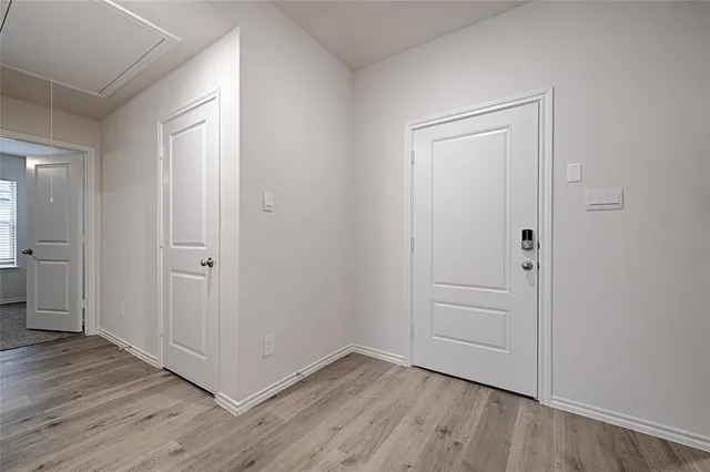 an empty room with wooden floor & closet area