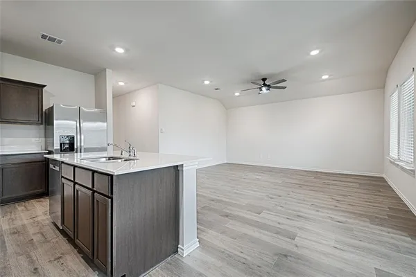a kitchen with a sink cabinets and wooden floor