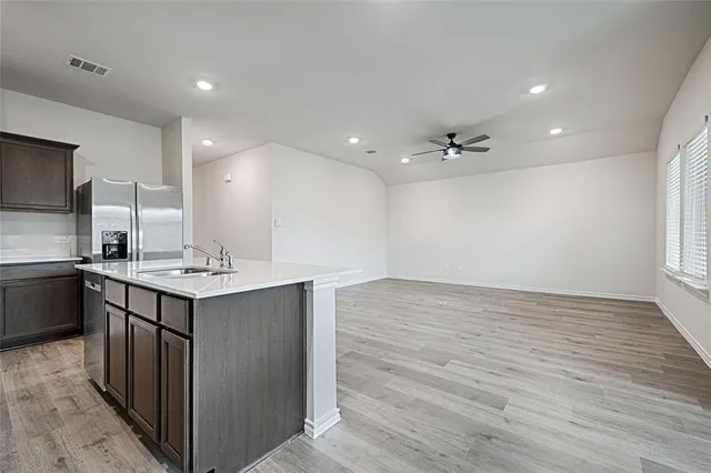 a kitchen with a sink cabinets and wooden floor