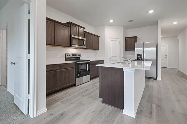 a kitchen with stainless steel appliances granite countertop a sink stove and refrigerator