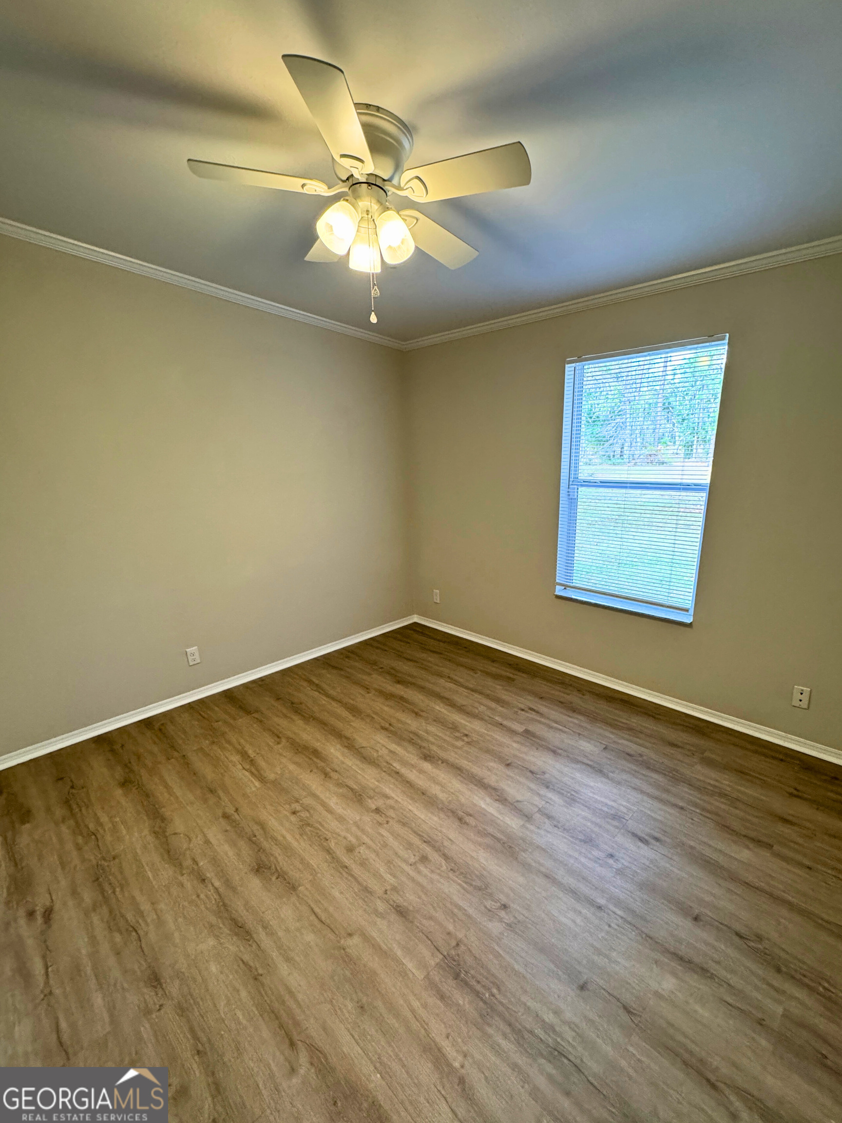 2554 Harrietts Bluff Road Woodbine, GA 31569 - Photo 28 of 35 an empty room with wooden floor and windows