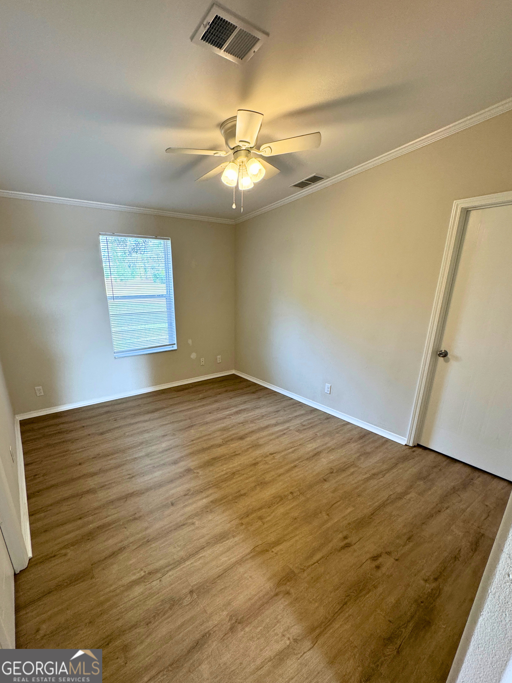 2554 Harrietts Bluff Road Woodbine, GA 31569 - Photo 30 of 35 an empty room with wooden floor and fan